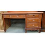 Mahogany four drawer desk with decorative carved frontage and sides. 140 x 75 x 65cm