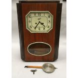 Wood surround striking wall clock with key and pendulum