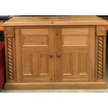 Solid pine two door small cupboard with turned supports and carved motifs , single internal shelf