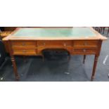 Antique oak kneehole desk with five drawers to front and green leather inlaid top.