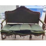 A Victorian carved three seater sofa upholstered in green fabric, in need of restoration. (af) (w