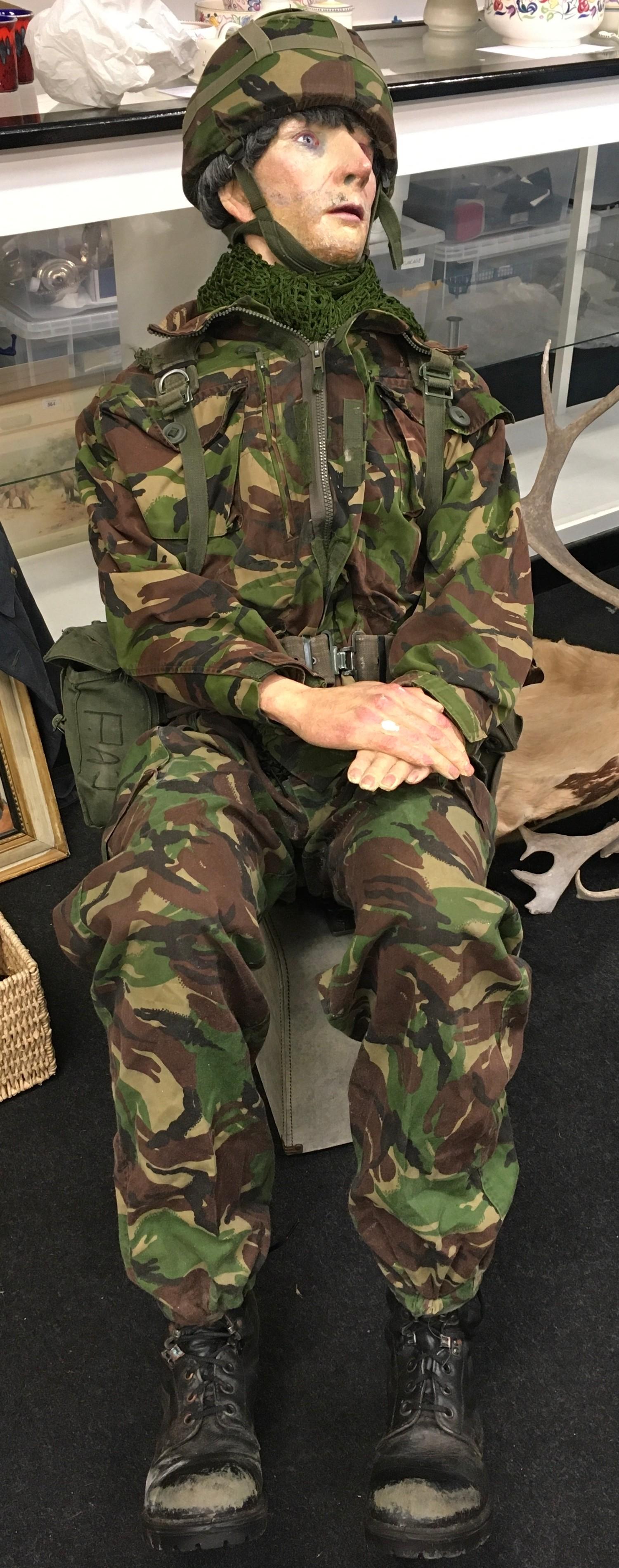 A seated full army mannequin camouflage of a paratrooper.