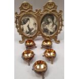 A Victorian twin brass photo frame together with a set of five matching three legged brass salts.
