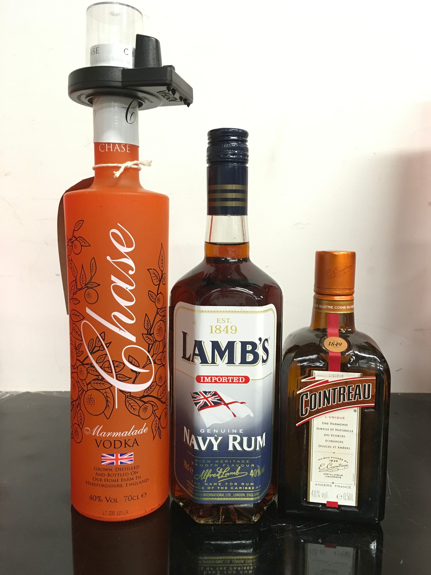 Three bottles of alcohol: Chase Marmalade Vodka 70cl, Lamb?s Navy Rum 70cl, Cointreau 50cl. Ref