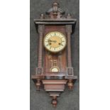 Mahogany decorative striking wall clock with key.