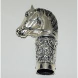 A walking cane handle stamped 800 in the form of a horse head.