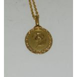 A yellow gold pendant necklace with embossed flower to centre.
