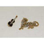 Gilded diamante cat brooch together a similar violin brooch