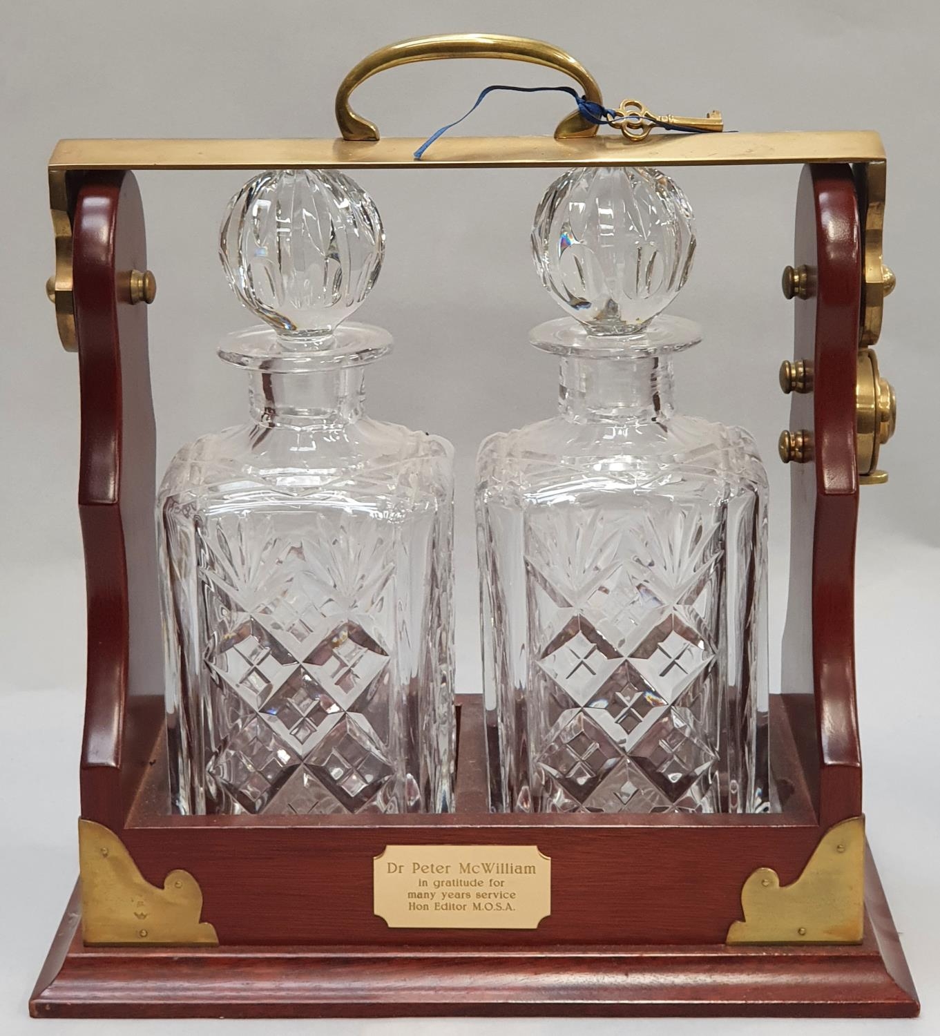 A pair of crystal cut glass decanters in tantalus with key.