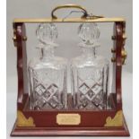 A pair of crystal cut glass decanters in tantalus with key.