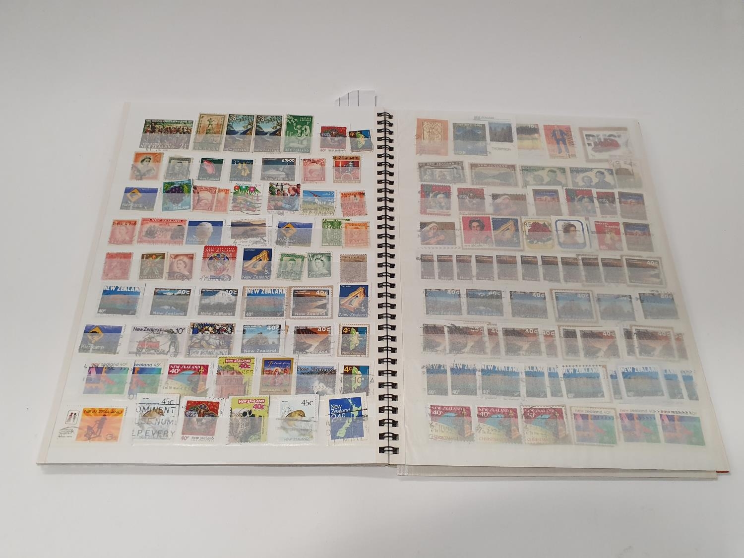 A multi-coloured stamp album 233 New Zealand.