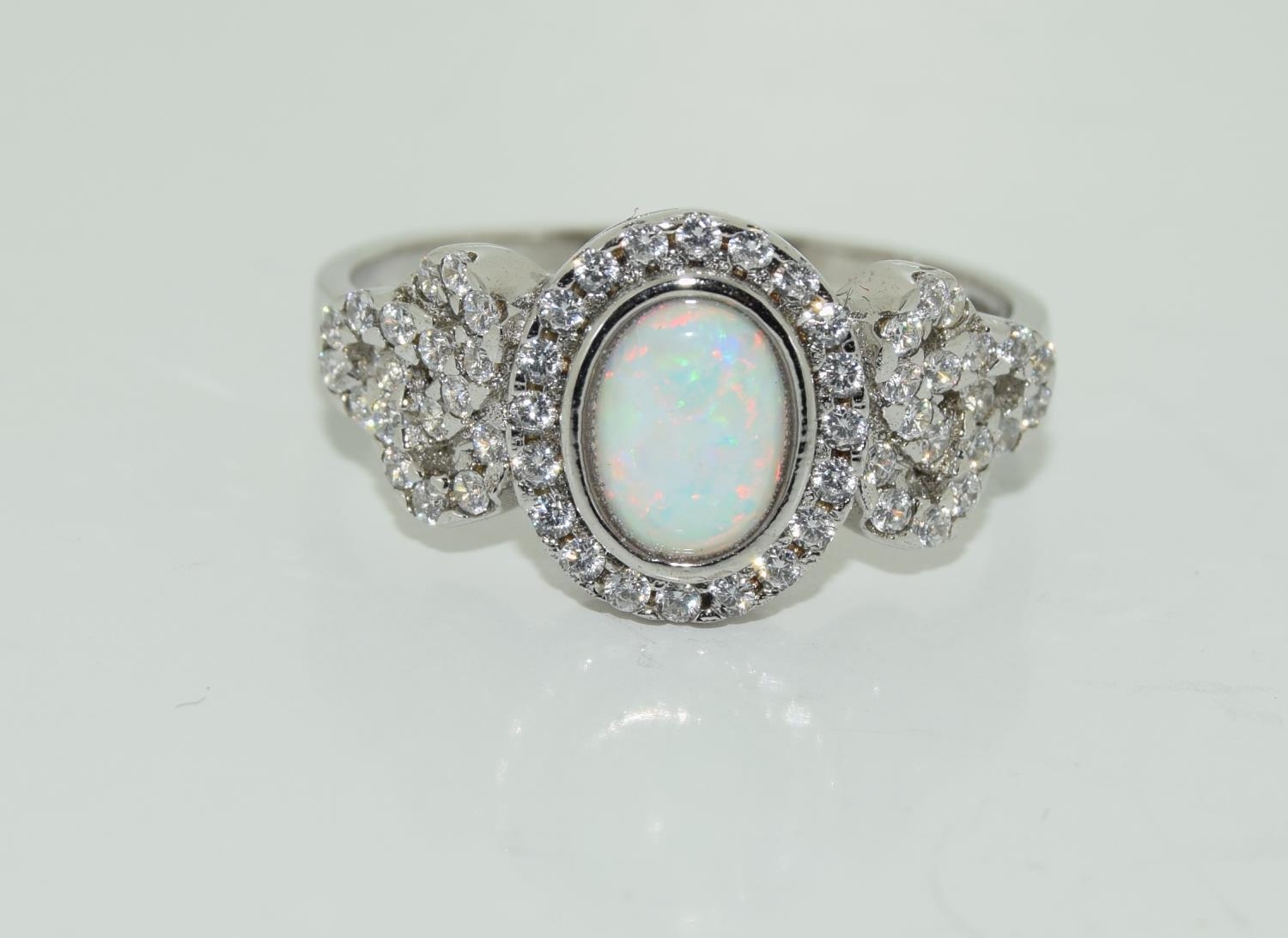 A silver CZ and opal paneled Art Deco style ring.