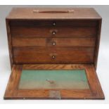 A vintage oak Neslein Jewellers tool cabinet with drop down lid to reveal four drawers with turned