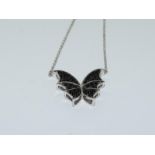 A silver black spinal butterfly necklace.