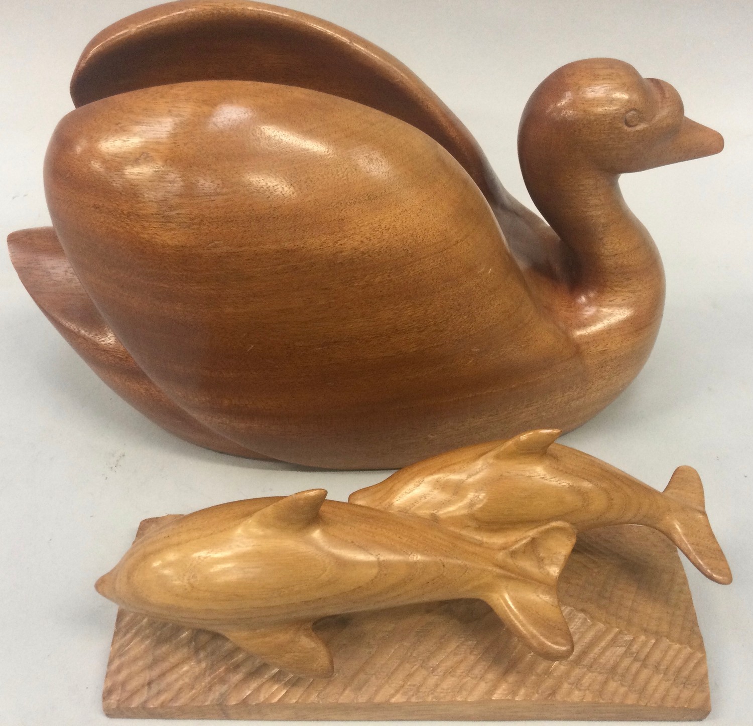 A quality wood carved treen Swan 38x22cm together with a pair of dolphins 27x14cm.