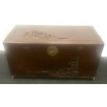 Oriental camphor wood chest of rectangular form with carved motifs on brass castors 100x53x49cm.