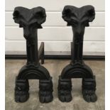 A pair of early cast iron fire dogs each measuring 51x57cm.