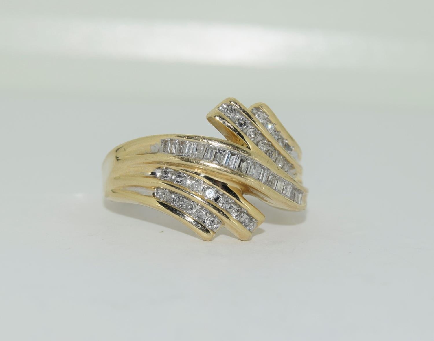 A large heavy gold and diamond swirl ring, Size U