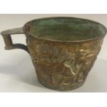 An Arts & Crafts brass Vapheio cup decorated with embossed figures.