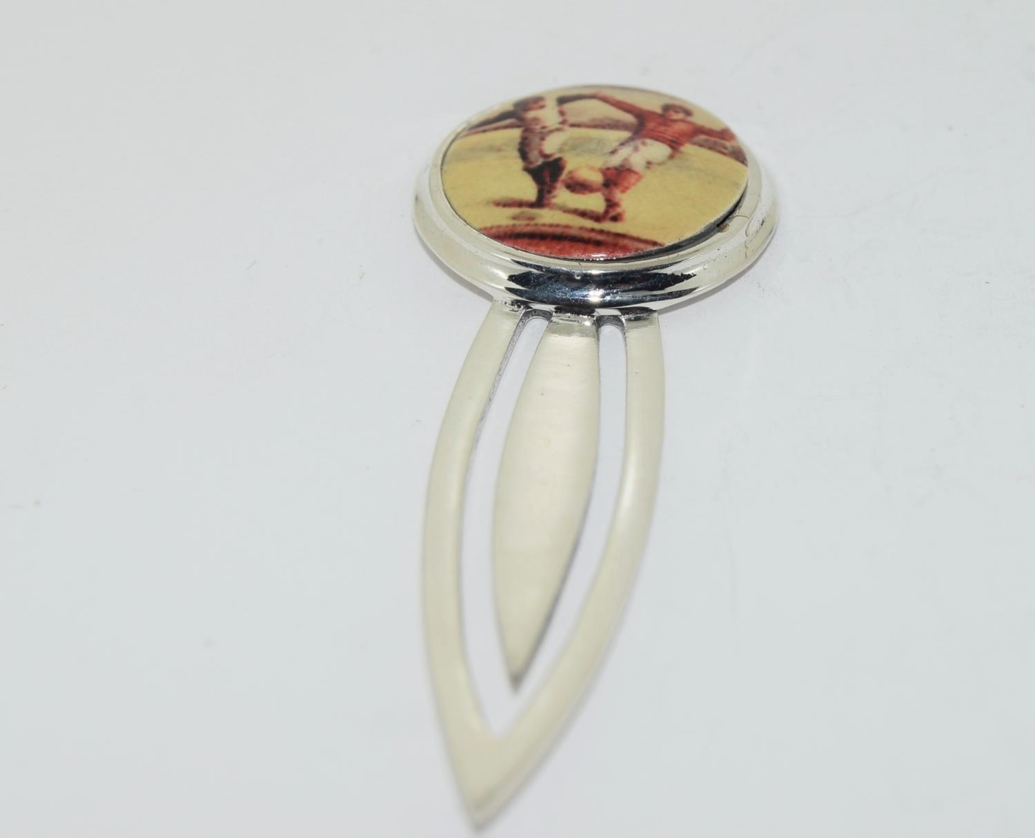 A sterling silver and enamel football bookmark