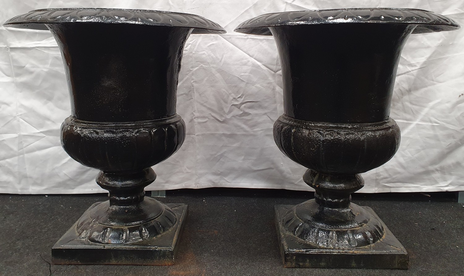 A pair of black painted cast iron Griechen style garden urns 59cm high 52cm diameter.