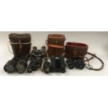 Five pairs of antique binoculars, three with leather cases.