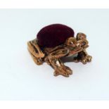 A copper frog pincushion.