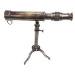 A brass telescope on tripod base.