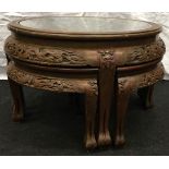 A Round oriental carved table with glazed top and four stools