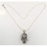 A silver CZ skull pendant necklace.