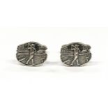 A pair of silver cuff links with golfing interest.