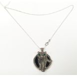 A substantial silver pendant necklace of cat form with emerald eyes.