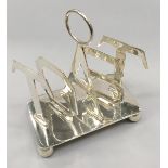 A silver plated toast rack on bun feet.