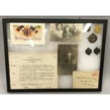 Selection of military framed items relating to WW1 to include pin badges, photographs and ephemera.
