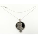 A silver pendant necklace with stylized Art Deco style figure set with ruby cabochon.