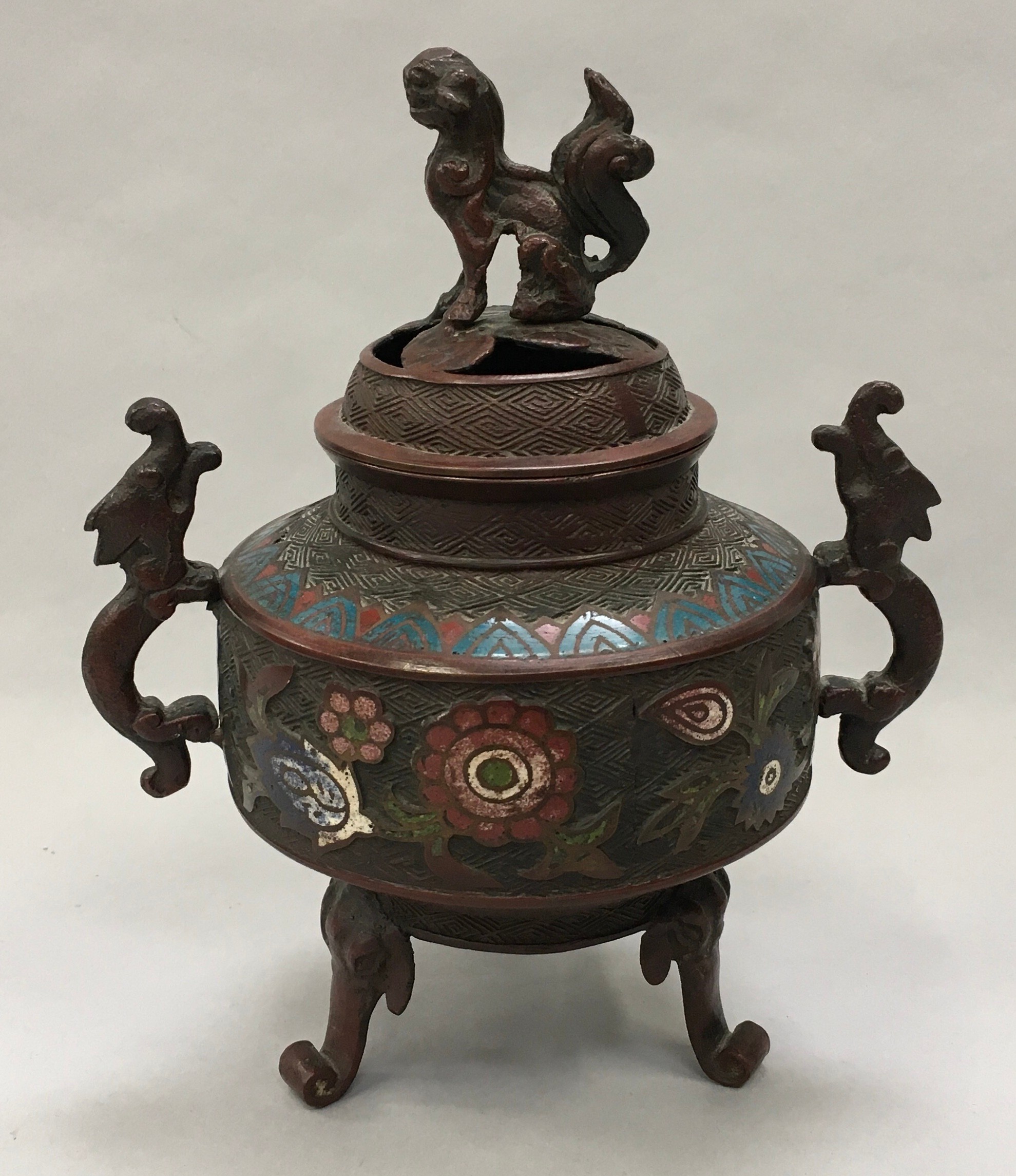 Oriental cloisonne incense burner with enamel decoration and dragon handles set on three legs