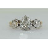 An 18ct yellow gold antique three stone diamond ring the central pear shaped diamond flanked by