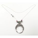 An unusual silver pendant magnifying glass surmounted by a nymph set with rubies.