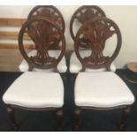 Set of four modern oriental hardwood dining chairs with carved backs and white fabric upholstered
