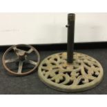 Large cast metal parasol base c/w a vintage metal wheelbarrow wheel