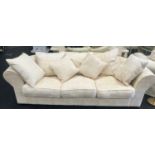 A large four seater settee with hexagonal back upholstered in beige fabric 270x120x70cm.
