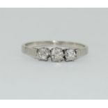 A Platinum three stone diamond ring. Size L