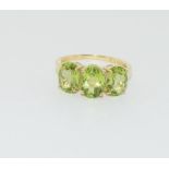 A 9ct Peridot three stone ring, Size N.