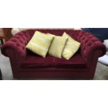 Two seater Chesterfield style settee with red button backed upholstery on bun feet 157x90v75cm. Seat
