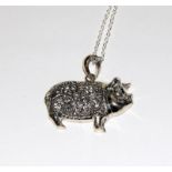 A silver pig pendant necklace.