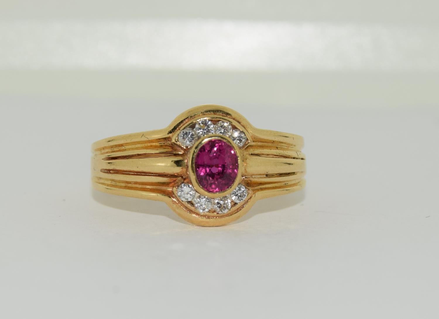 An 18ct gold ring with oval ruby and diamond, Size Q