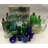 Large collection of mixed coloured glassware to include medicine bottles with a modern glass display