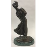 Bronze model of a lady golfer on a green marble base 34cm tall