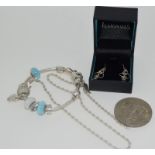 A silver coloured charm bracelet with charms together with A prince of wales and lady Diana coin,