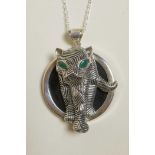 A sterling silver pendant necklace decorated with a panther with inset green stone eyes, 2" drop
